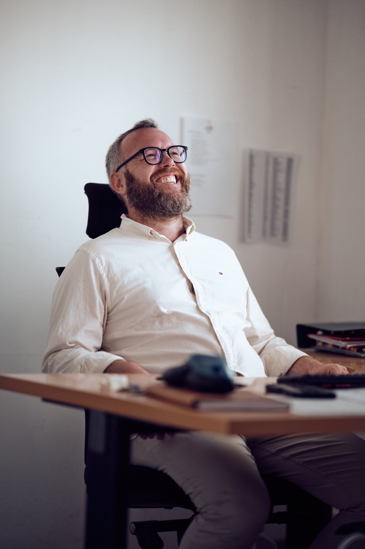 Portrait corporate — dirigeant à lunettes à son poste de travail, lumière naturelle — photographie Romain Cruse