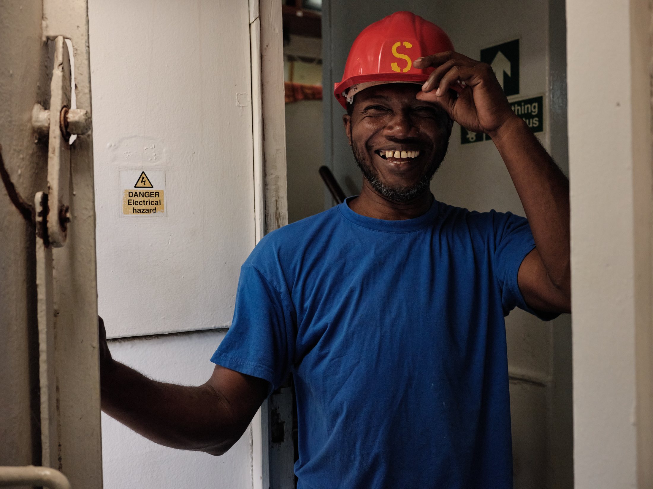 Marin au casque rouge frappé du S, à bord — photographie Romain Cruse
