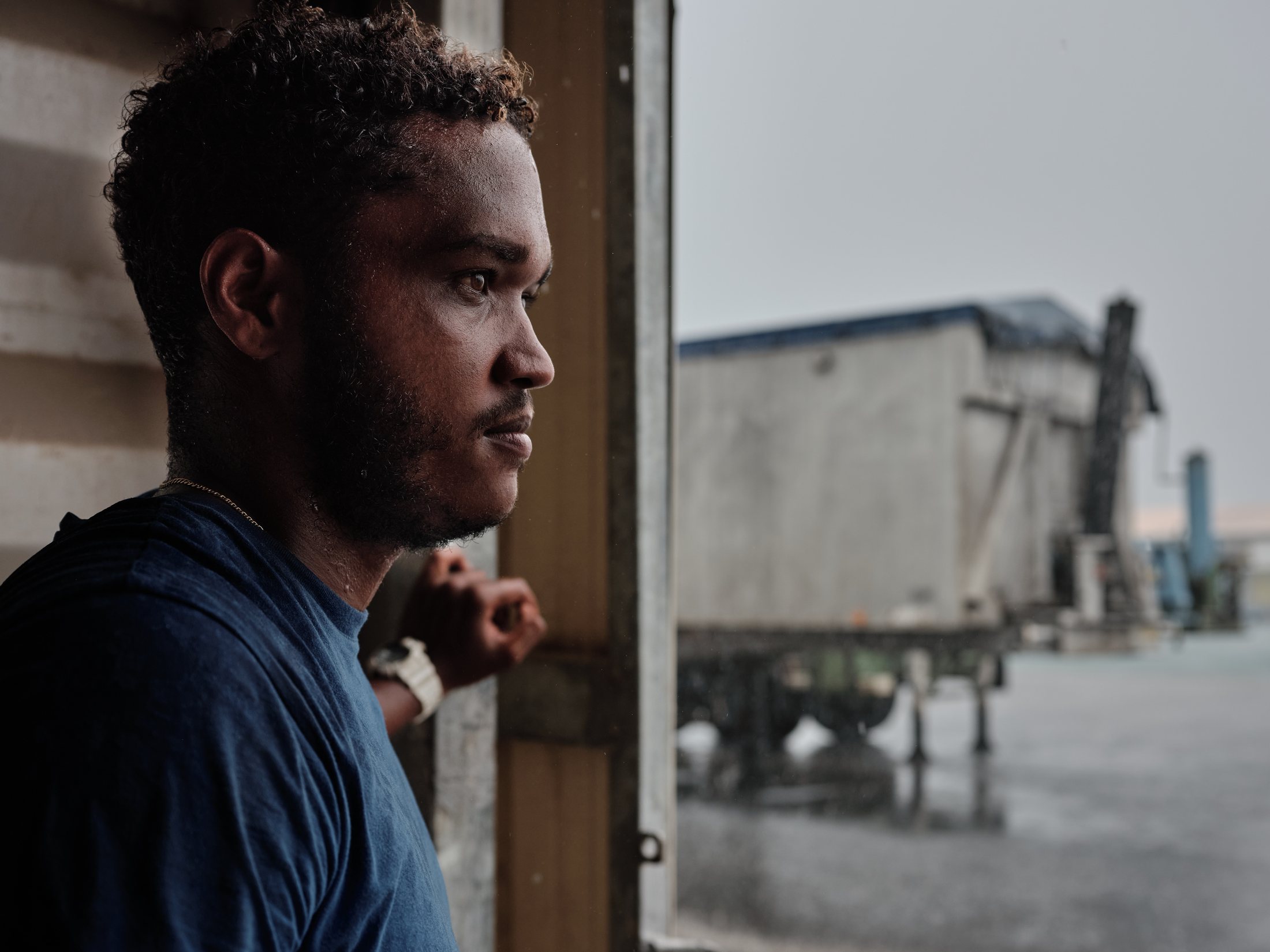 Marin de profil regardant le quai sous la pluie — photographie Romain Cruse